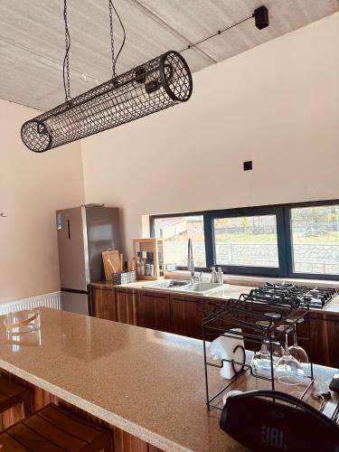 a kitchen with a counter top and a large light fixture at Alpine Escape Kazbegi in Stepantsminda