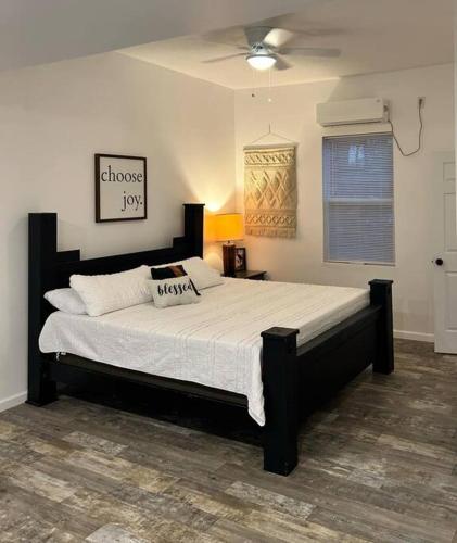 a bedroom with a large bed with a black frame at 7th Heaven in Mena