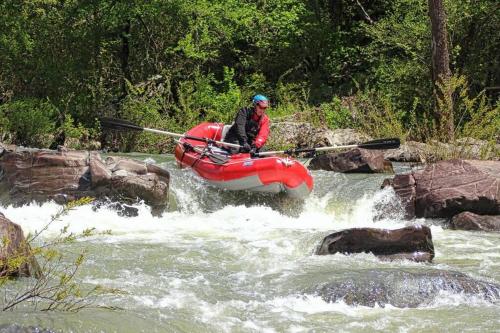 a man is in a raft in a river at 7th Heaven in Mena