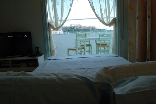 a bedroom with a bed and a view of a balcony at Acropolis View Studio in Monastiraki in Athens