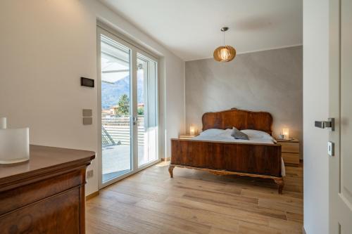 a bedroom with a bed and a large window at Villa Sunrise - Luxury property with pool & large private garden, few steps from the beach, ideal for families and people with mobility issues in Dervio