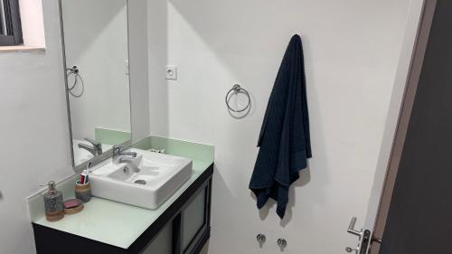 a white bathroom with a sink and a mirror at CasaZina in Tarrafal