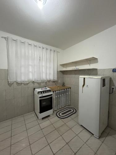 a kitchen with a stove and a refrigerator at Apartamento Tati Ortega in Ilha Comprida
