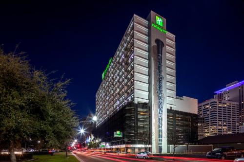a tall building with a green sign on it at Holiday Inn New Orleans-Downtown Superdome by IHG in New Orleans