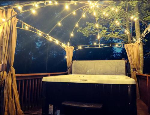 a jacuzzi tub sitting under a tent with lights at Trailseeker Cabin w King Bed Hot Tub at Red River Gorge Natural Bridge in Stanton
