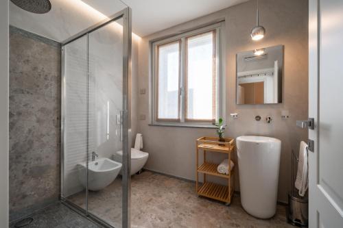 a bathroom with a shower and a sink and a toilet at Villa Sunrise - Luxury property with pool & large private garden, few steps from the beach, ideal for families and people with mobility issues in Dervio
