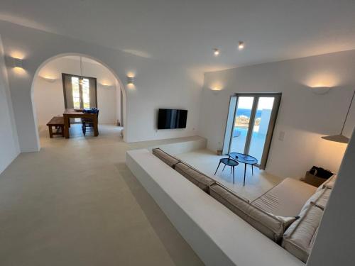 アンティパロス島にあるSaliagos villas complex with private poolsのソファとテーブルのある白いリビングルーム