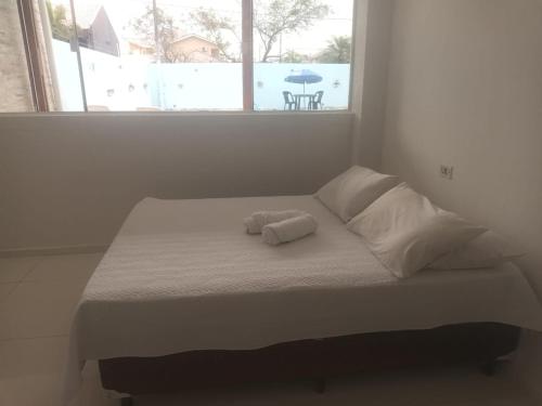ein Bett mit zwei Handtüchern darauf in einem Zimmer mit Fenster in der Unterkunft Casa na praia in Pontal do Paraná