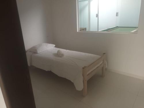 Bett in einem weißen Zimmer mit Spiegel in der Unterkunft Casa na praia in Pontal do Paraná