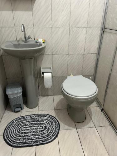 a bathroom with a toilet and a sink at Apartamento Tati Ortega in Ilha Comprida