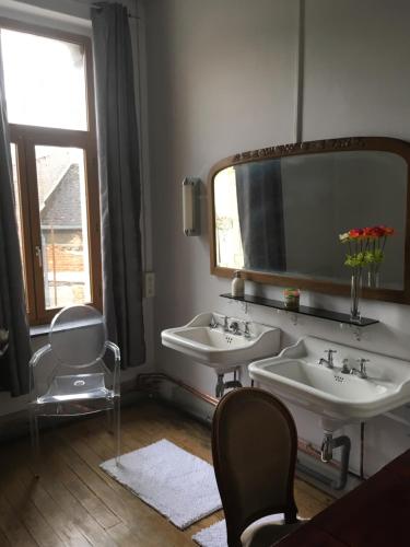 une salle de bain avec deux lavabos et un grand miroir dans l'établissement Belle Maison Laonnoise d'Antan, à Laon