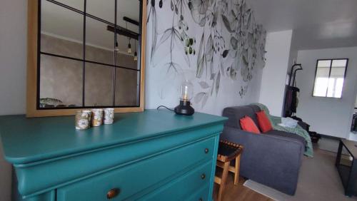 a blue dresser in a living room with a couch at Le Céladon in Dijon