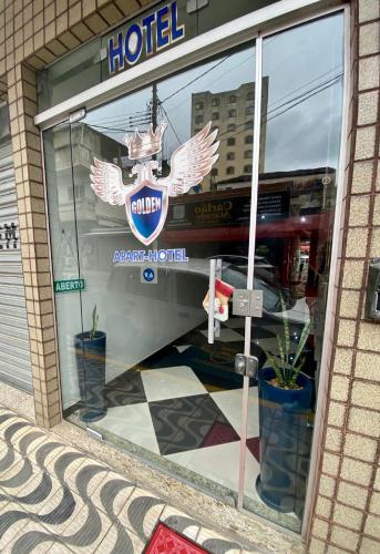 a hotel sign in a window of a building at Golden Apart Hotel in Aparecida