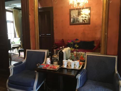 Cette chambre comprend une table avec deux chaises et un miroir. dans l'établissement Belle Maison Laonnoise d'Antan, à Laon