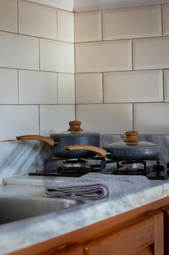 two pots on top of a stove in a kitchen at Villa Estrela Bungalow in Itacaré