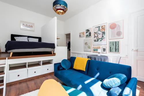 - un salon avec un canapé bleu et un lit dans l'établissement Plein centre, Parking privé et securisé, 1 lit et 1 couchage d'appoint pour enfant, à Amiens