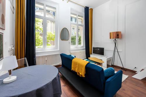 un salon avec un canapé et une table dans l'établissement Plein centre, Parking privé et securisé, 1 lit et 1 couchage d'appoint pour enfant, à Amiens