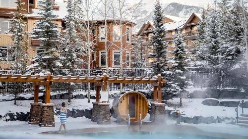 a woman standing in the snow in front of a building at Stoneridge Mountain Resort in Canmore