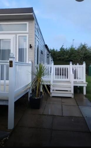 a white house with a porch and a white fence at 14 morningside in Skegness
