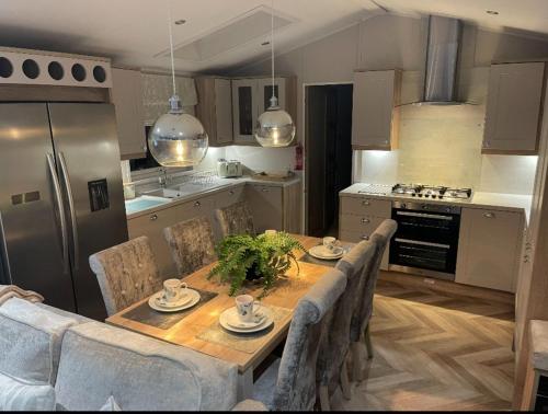 a kitchen with a wooden table with chairs and a tableasteryasteryasteryasteryastery at 14 morningside in Skegness