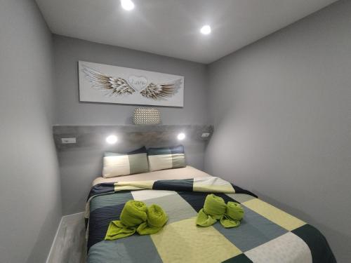 a bedroom with a bed with two green bows on it at Arenas 50, 100 mt d playa ingles in Playa del Ingles