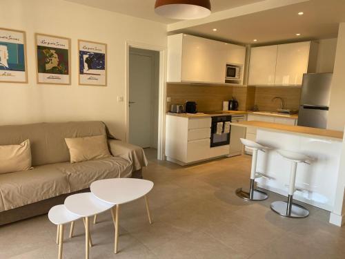 un salon avec un canapé et une table et une cuisine dans l'établissement F2 Centre DEAUVILLE Lit 180 Parking gratuit, à Deauville