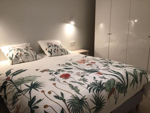 une chambre avec un lit avec un couvre-lit fleuri dans l'établissement F2 Centre DEAUVILLE Lit 180 Parking gratuit, à Deauville