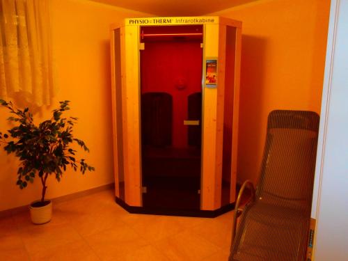 a elevator in a room with a chair and a plant at Pension & Apartments Ertl in Seeboden