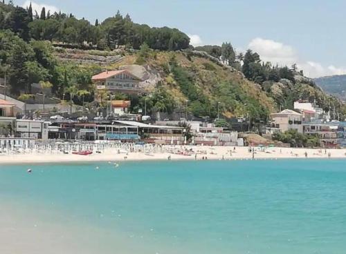 a beach with a bunch of people on the water at La Timpa house in Satriano