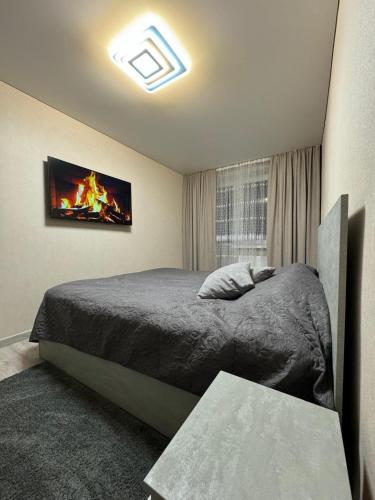 a bedroom with a bed and a tv on the wall at Apartments in Bălţi