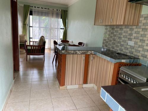 a kitchen with wooden cabinets and a table in it at House of Light in Arua