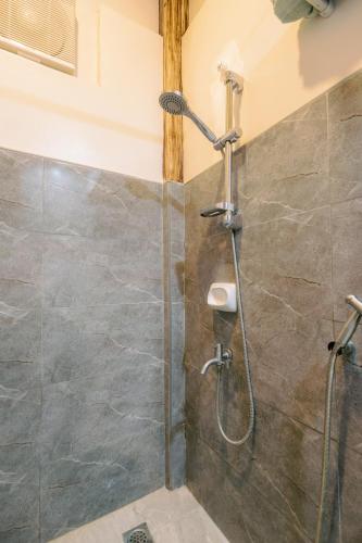 a shower with a glass door in a bathroom at Busai Dream Falls Resort in Loboc