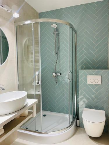 a bathroom with a shower and a toilet and a sink at Hotel & Restauracja Kormoran in Orzysz