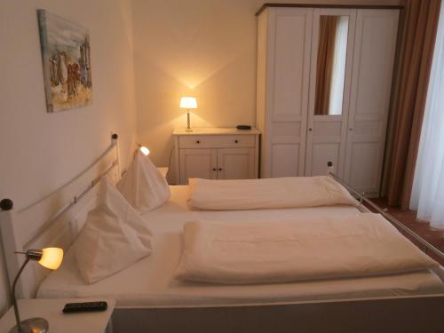 a bedroom with two beds and a lamp on a table at Pension & Apartments Ertl in Seeboden