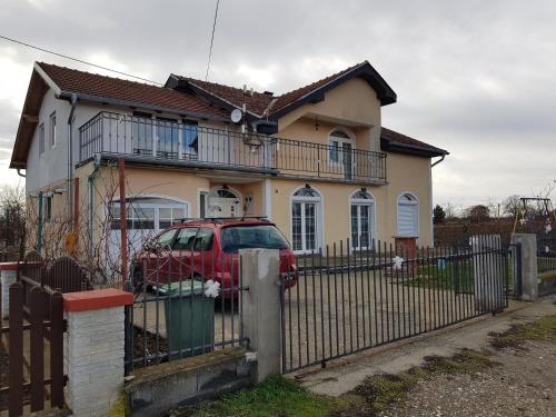 a red car parked in front of a house at Sobe i apartmani Djordjevic in Mladenovac