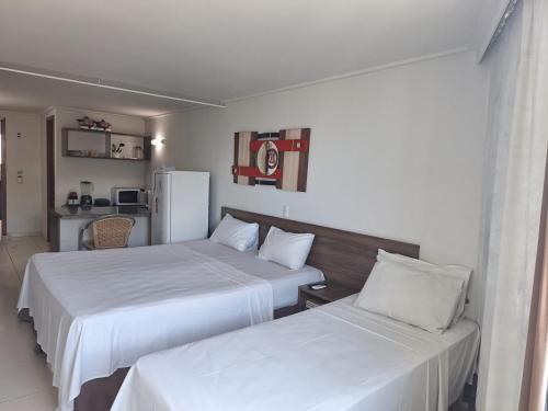 zwei Betten in einem Hotelzimmer mit weißen Laken in der Unterkunft Apartamento BLUE in João Pessoa