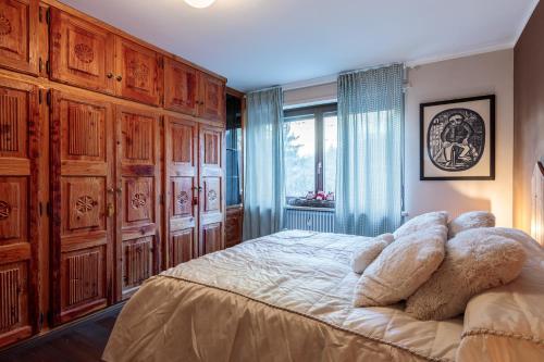 una camera da letto con un letto con armadi in legno e una finestra di Maison Federica a Pré-Saint-Didier