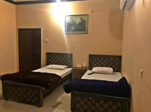 a room with two beds in a room at Babar House in Faisalabad