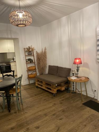 a living room with a couch and a table at Appartement COSY in Sartilly