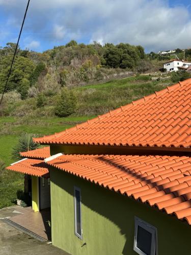an orange and green building with an orange roof at Green House in Calheta