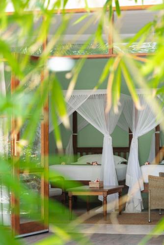a bedroom with two beds with mosquito nets at Kisiwa on the Beach in Paje