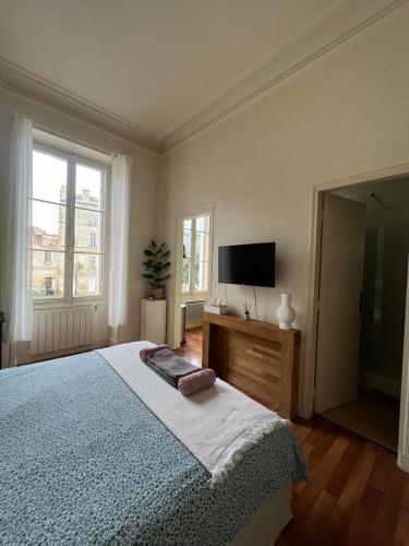 une chambre avec un lit et une télévision à écran plat dans l'établissement Studio dans le centre, à Bordeaux
