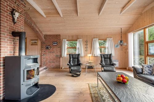 a living room with a fireplace and a brick wall at Cozy And Spacious Holiday Home Near Torup Strand Close To The North Sea in Fjerritslev