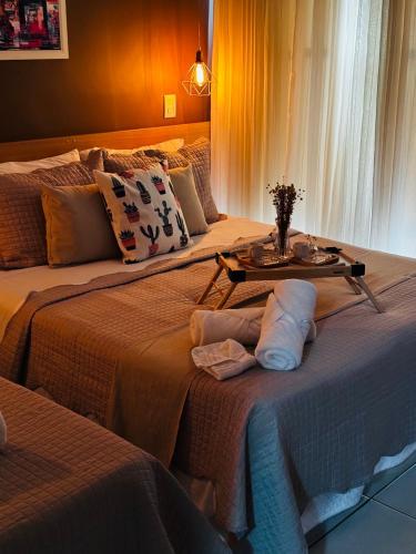 a hotel room with two beds with a table on it at Flat B306 Village Aldeia das Águas in Barra do Piraí