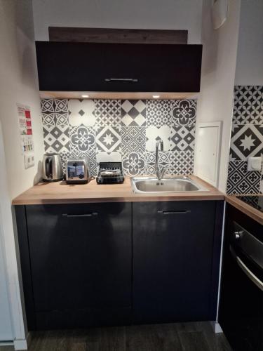 une cuisine avec un évier et un plan de travail dans l'établissement Appartement Cosy Disneyland, à Montévrain