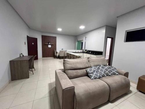 a living room with a couch and a kitchen at Apartamento completo e espaçoso in Marabá