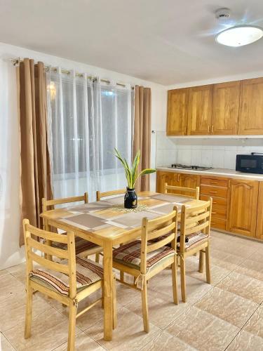a kitchen with a wooden table with two chairs and a plant at Seashells Home in Panglao Island