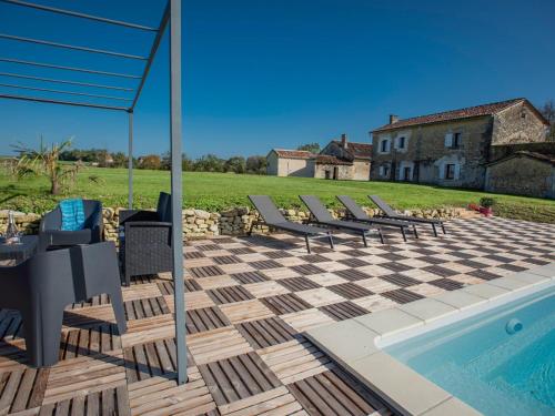 une terrasse avec des chaises, une piscine et une maison dans l'établissement Les Escures 2, à Champagne-et-Fontaine