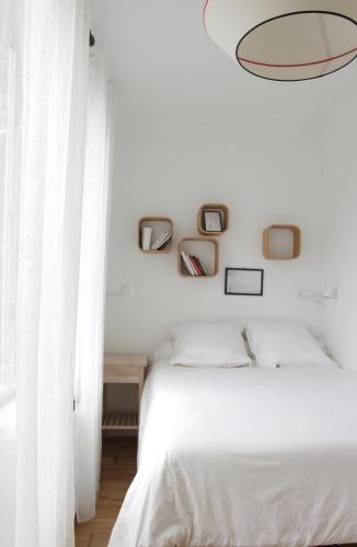 - une chambre avec des murs blancs et un lit blanc dans l'établissement Les Sables, au Crotoy