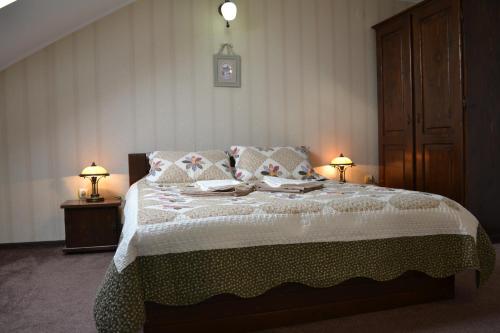 a bedroom with a large bed with two lamps at vila Dariana in Vatra Dornei